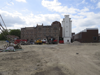 907260 Gezicht op de voormalige Cereolfabriek, die gerestaureerd wordt, met rechts nieuwbouwwoningen, vanaf de Kanaalweg.